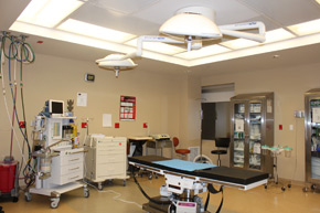 A surgical bed is surrounded by a equipment and supplies in the operating room at the Plastic Surgery Center of Westchester.